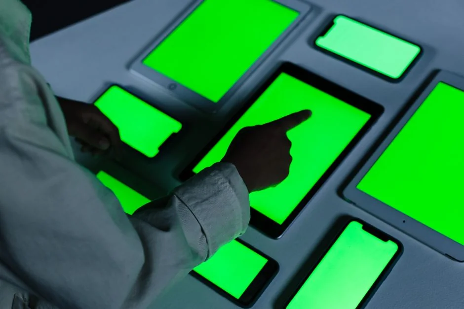 Gros plan sur un smartphone accompagné d’un stylet, posé sur une surface rouge éclatante, mettant en valeur une technologie moderne.